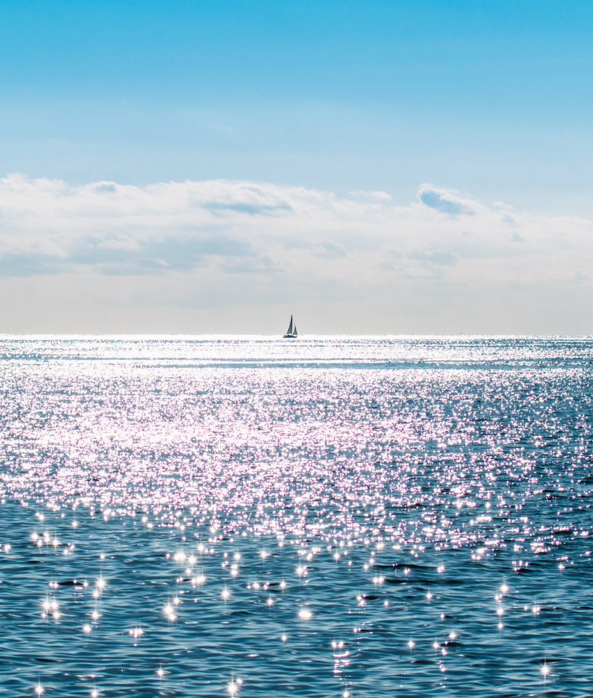 太陽の光を反射して輝く海の写真